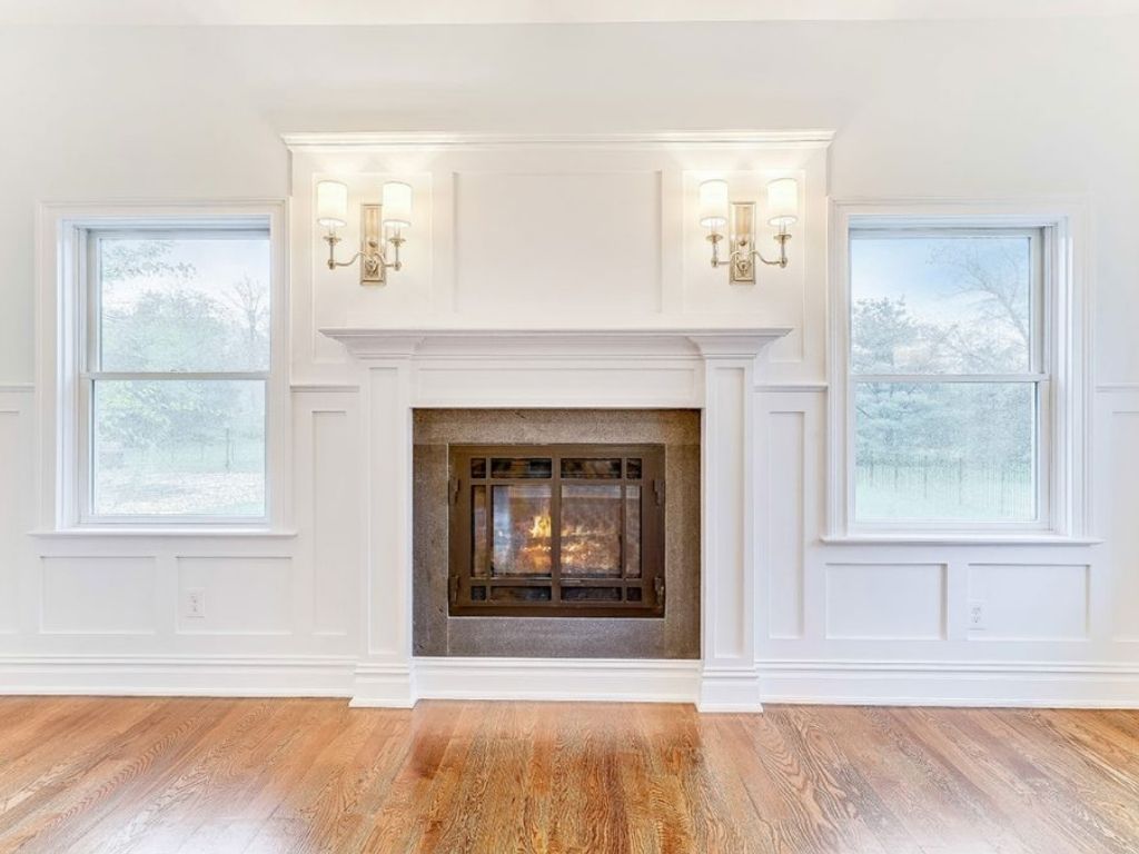 Living room fireplace with custom built-ins and paneling designed for smart storage and elegant home organization.