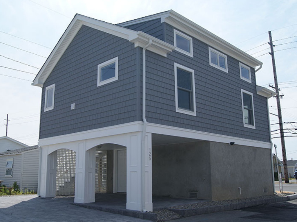 Elevated coastal-style custom homes in New Jersey with raised foundation and modern siding designed for durability and coastal living.